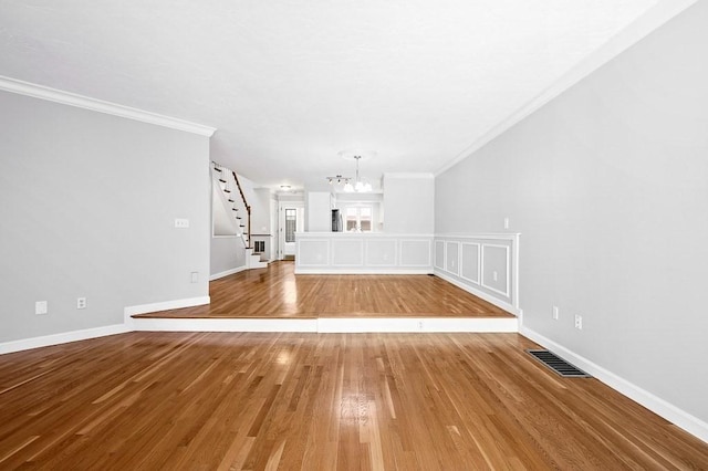 30 Eastern Point Dr Unit 30, Shrewsbury, MA 01545 - unfurnished living room featuring ornamental molding, a chandelier, stairs, light wood-type flooring, and baseboards