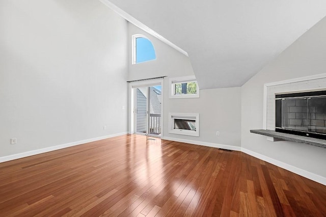 30 Eastern Point Dr Unit 30, Shrewsbury, MA 01545 - unfurnished living room with a glass covered fireplace, baseboards, wood finished floors, and high vaulted ceiling