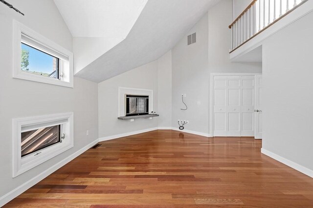 30 Eastern Point Dr Unit 30, Shrewsbury, MA 01545 - unfurnished living room with a fireplace, wood finished floors, baseboards, and high vaulted ceiling