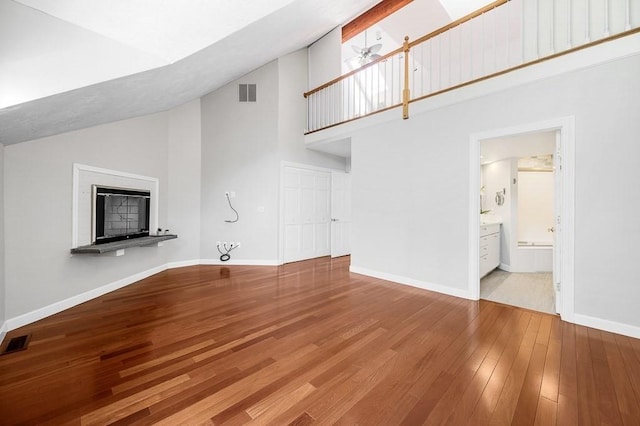 30 Eastern Point Dr Unit 30, Shrewsbury, MA 01545 - unfurnished living room with high vaulted ceiling, hardwood / wood-style flooring, baseboards, a fireplace with raised hearth, and a ceiling fan