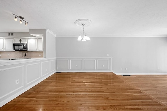 30 Eastern Point Dr Unit 30, Shrewsbury, MA 01545 - unfurnished dining area with a chandelier, ornamental molding, and light wood finished floors