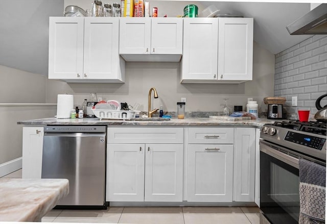 kitchen featuring white cabinets, appliances with stainless steel finishes, and wall chimney range hood