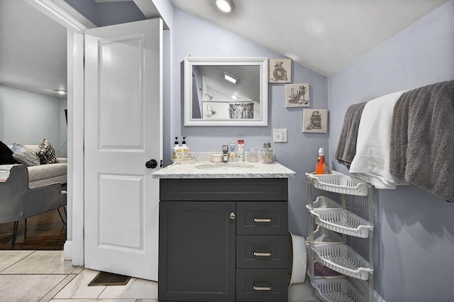 bathroom featuring tile patterned floors, vanity, and lofted ceiling