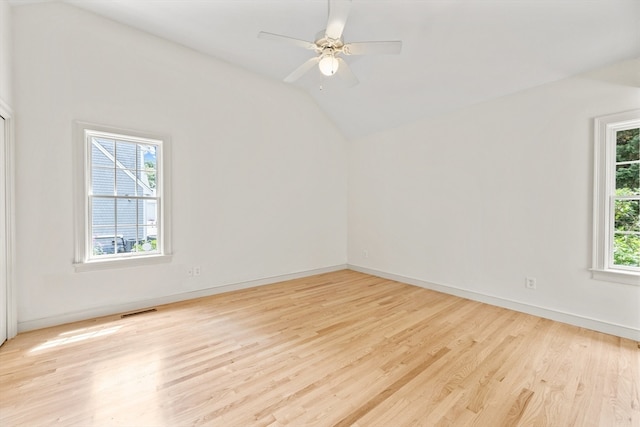 unfurnished room featuring plenty of natural light, lofted ceiling, and light hardwood / wood-style floors