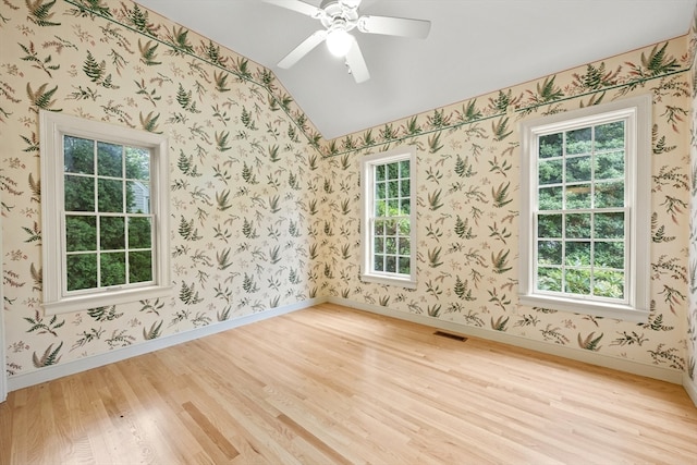 spare room with ceiling fan, light hardwood / wood-style flooring, and vaulted ceiling