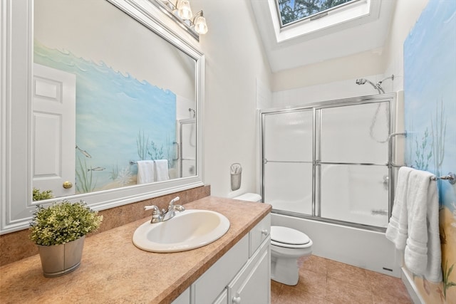 full bathroom with combined bath / shower with glass door, toilet, tile patterned floors, vanity, and vaulted ceiling with skylight