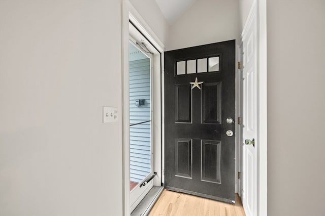 entryway with light hardwood / wood-style flooring and vaulted ceiling