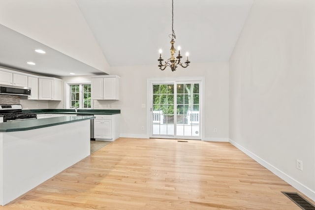 kitchen featuring light wood-type flooring, stainless steel appliances, white cabinetry, and pendant lighting