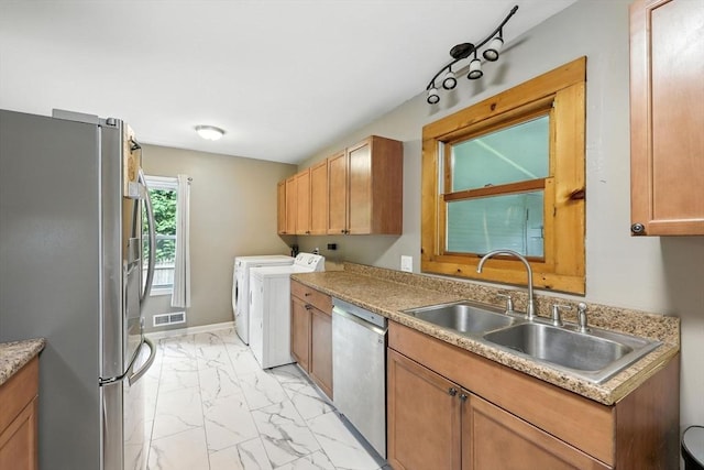 14 Carlton St, South Hadley, MA 01075 - kitchen featuring stainless steel appliances, independent washer and dryer, light marble finish flooring, light countertops, and brown cabinets