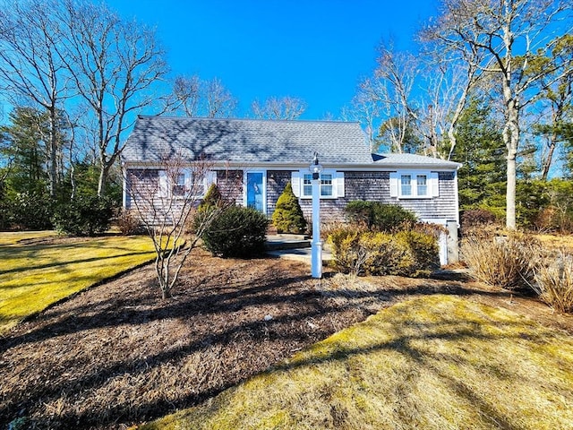 view of front of property featuring a shingled roof and a front lawn