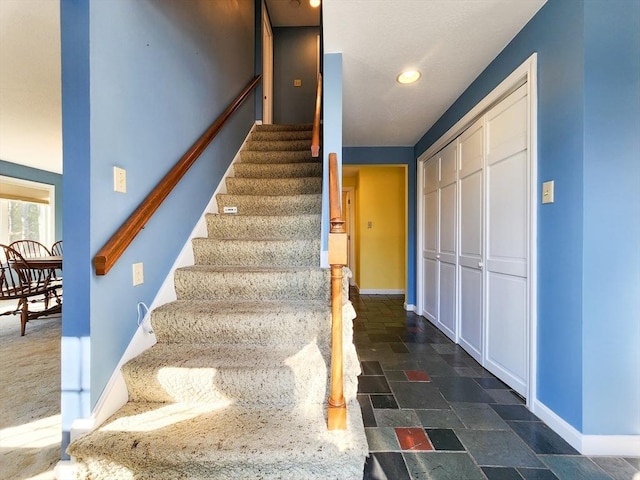 stairs with baseboards, recessed lighting, and stone tile floors