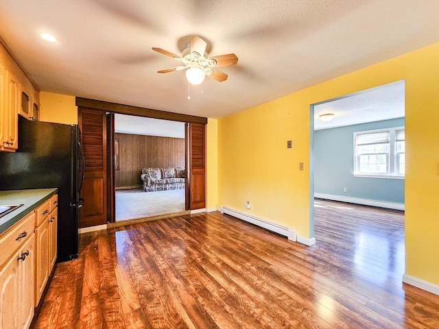 kitchen with ceiling fan, dark wood-style flooring, and baseboard heating