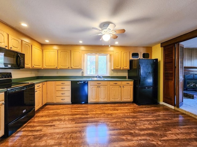 kitchen featuring ceiling fan, a textured ceiling, wood finished floors, light brown cabinetry, and black appliances