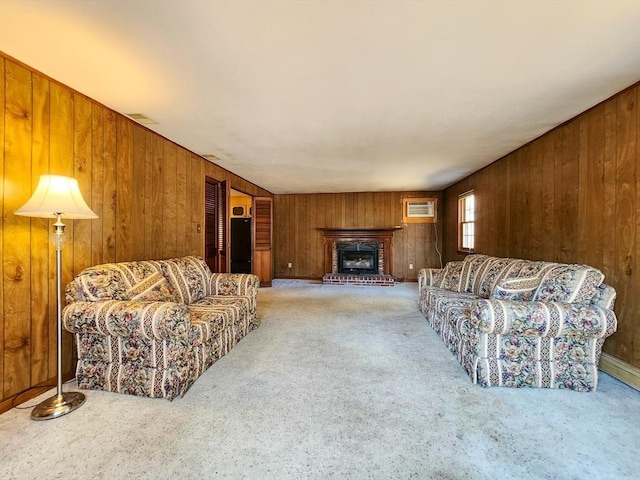 carpeted living room with a wall mounted air conditioner, a fireplace, visible vents, and wooden walls