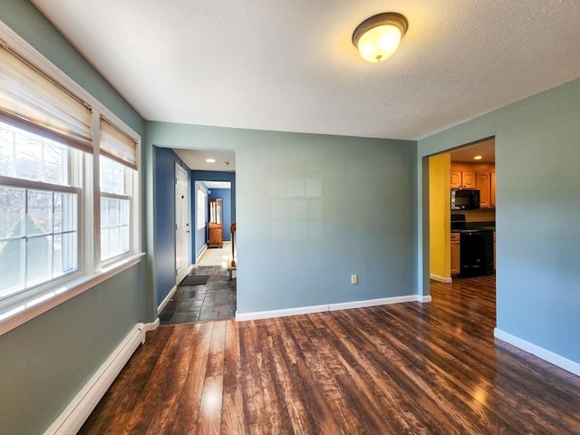 empty room with a baseboard heating unit, a textured ceiling, dark wood-style floors, and baseboards