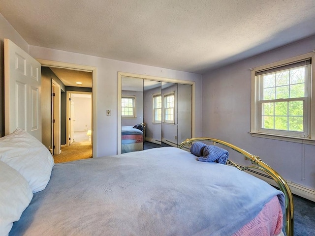 bedroom featuring a closet, dark carpet, and a textured ceiling