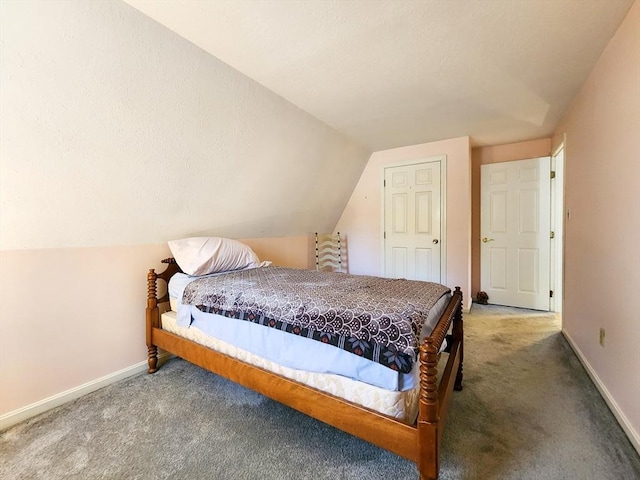 carpeted bedroom featuring lofted ceiling and baseboards