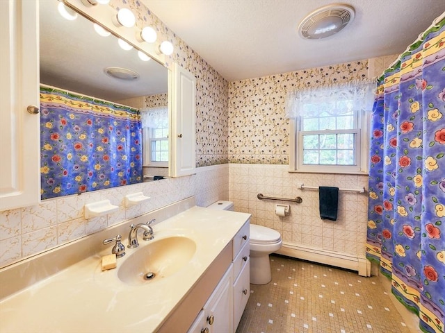 full bathroom with a healthy amount of sunlight, toilet, visible vents, and baseboard heating