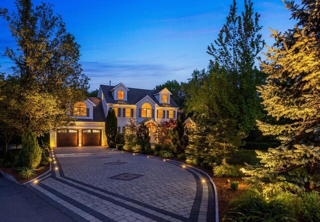 traditional-style house with an attached garage and decorative driveway