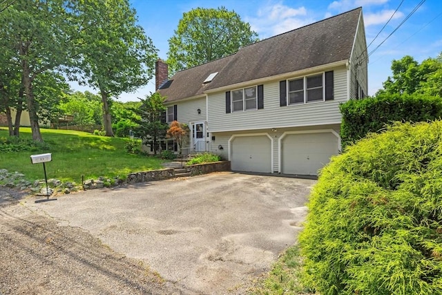 18 Bismark St, Dedham, MA 02026 - raised ranch featuring a chimney, asphalt driveway, a garage, and a front lawn