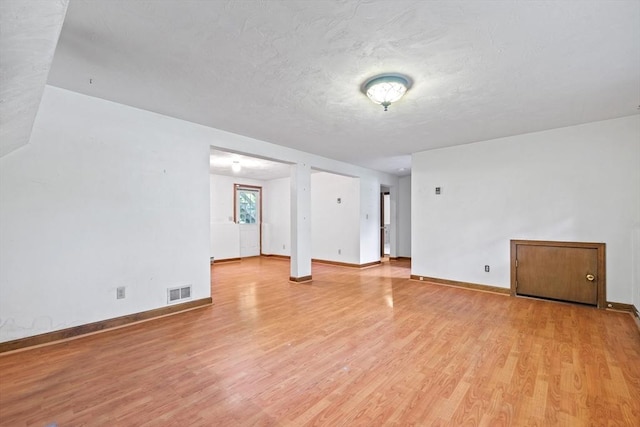 18 Bismark St, Dedham, MA 02026 - empty room with light wood-style flooring and a textured ceiling