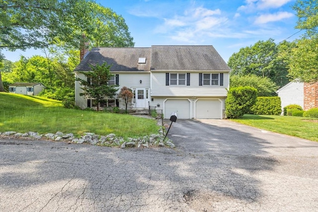 18 Bismark St, Dedham, MA 02026 - view of front facade with a chimney, a garage, asphalt driveway, and a front yard