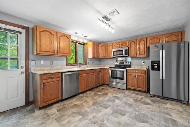 18 Bismark St, Dedham, MA 02026 - kitchen with stainless steel appliances, brown cabinetry, and light countertops