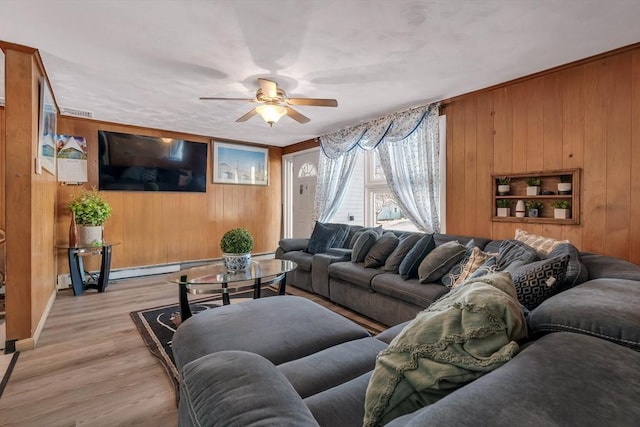 living room with ceiling fan, wooden walls, light hardwood / wood-style floors, and a baseboard radiator