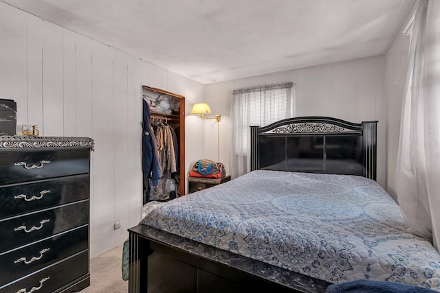 carpeted bedroom with a walk in closet and a closet