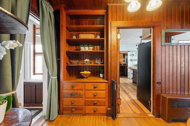 interior space with wood walls and light hardwood / wood-style flooring