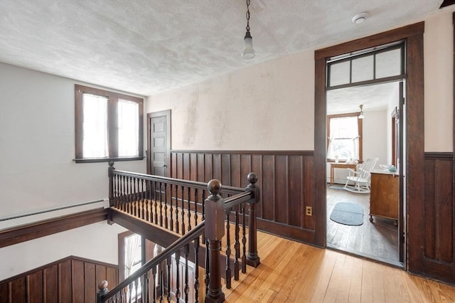 interior space featuring a textured ceiling, light hardwood / wood-style flooring, and a baseboard heating unit