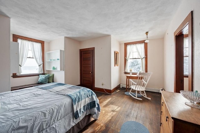 bedroom with a textured ceiling, baseboard heating, and dark hardwood / wood-style flooring