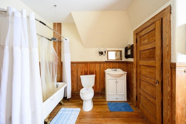 full bathroom with hardwood / wood-style flooring, toilet, vanity, and shower / tub combo with curtain