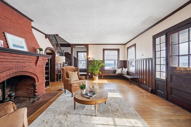 interior space featuring a brick fireplace, hardwood / wood-style floors, and crown molding