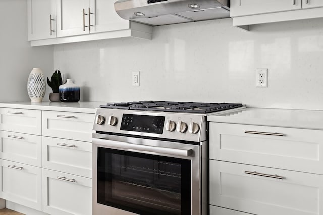 kitchen featuring ventilation hood, white cabinetry, and stainless steel range with gas stovetop