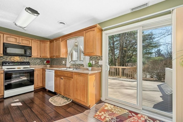 kitchen featuring visible vents, white dishwasher, a sink, electric range oven, and black microwave