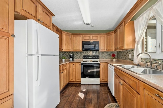 kitchen featuring white appliances, light countertops, dark wood-type flooring, and a sink