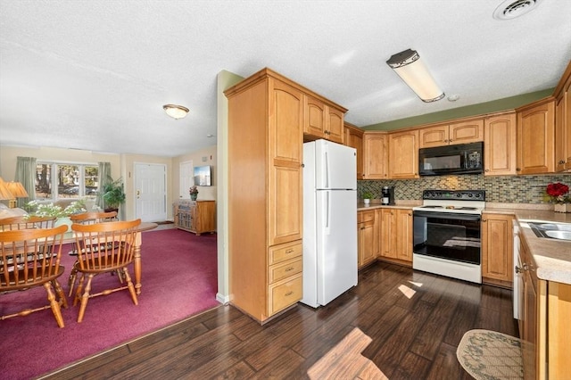 kitchen with visible vents, black microwave, light countertops, freestanding refrigerator, and electric range