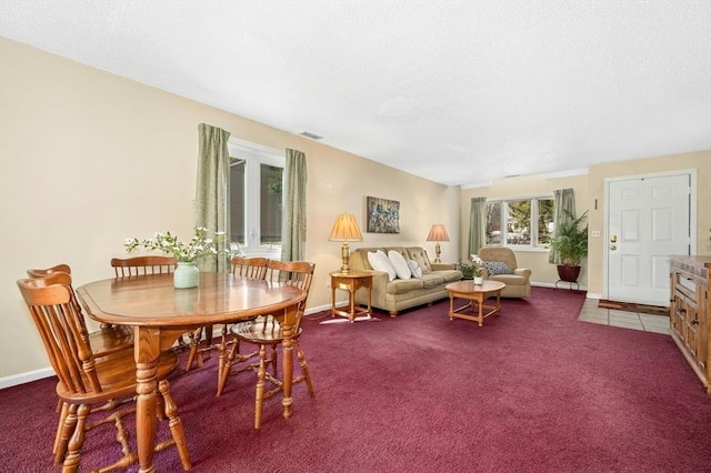 carpeted dining room with baseboards, visible vents, and a textured ceiling