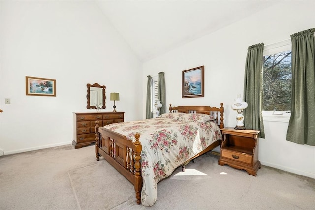 bedroom with high vaulted ceiling, baseboards, and light carpet