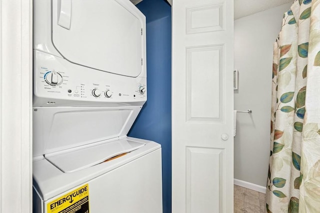 laundry area featuring stacked washer / dryer, laundry area, and baseboards