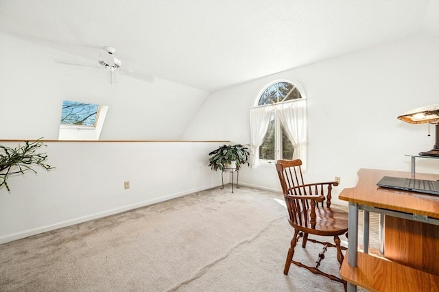 carpeted office featuring lofted ceiling with skylight and baseboards