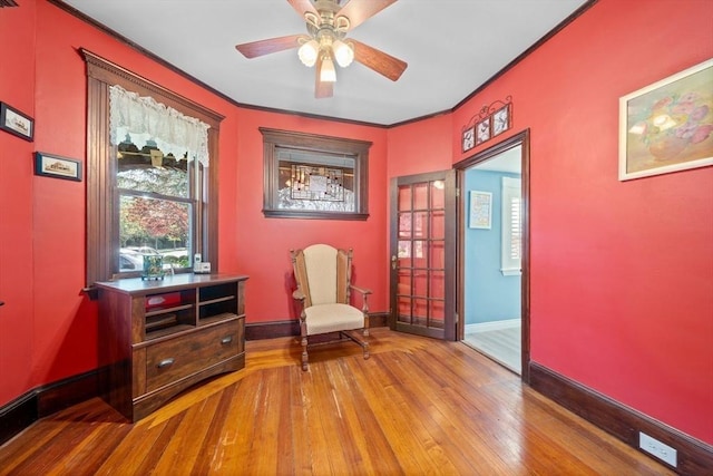 sitting room with baseboards, ornamental molding, ceiling fan, and hardwood / wood-style flooring