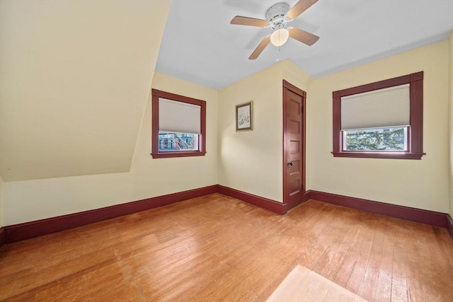 spare room featuring baseboards, a ceiling fan, and light wood finished floors