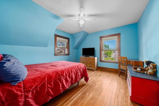 bedroom with a ceiling fan, baseboards, vaulted ceiling, and light wood-style flooring