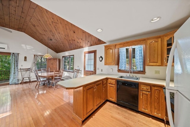 kitchen featuring light wood-type flooring, a sink, light countertops, a peninsula, and black dishwasher