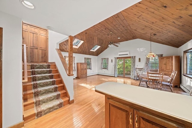kitchen with a ceiling fan, light wood-type flooring, a wealth of natural light, and a wall mounted air conditioner
