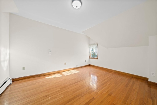 additional living space with baseboards, baseboard heating, hardwood / wood-style floors, and lofted ceiling