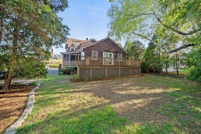 back of property with a sunroom, a yard, and a deck