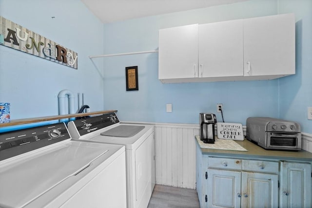 laundry room with cabinet space, independent washer and dryer, light wood-style floors, a wainscoted wall, and a toaster